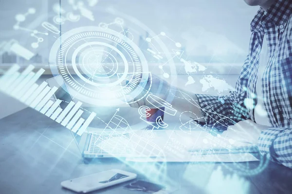 Arka planda dizüstü bilgisayarda çalışan iş adamlarının çoklu pozları. Uluslararası iş hologramı önde. Başarı kavramı.