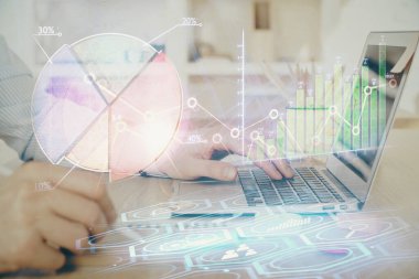 Arka planda dizüstü bilgisayar üzerinde çalışan adam ile borsa grafiği çoklu pozlama. Finansal analiz kavramı.