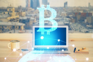 Engelleme zinciri ve kripto ekonomi temalı hologram ve bilgisayar geçmişi olan bir masa. Bitcoin kripto para kavramı.