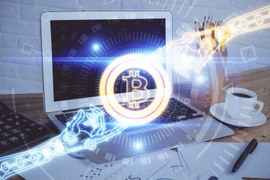Engelleme zinciri ve kripto ekonomi temalı hologram ve bilgisayar geçmişi olan bir masa. Bitcoin kripto para kavramı.