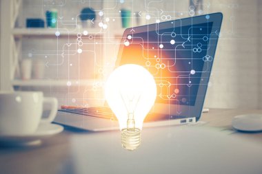 Bilgisayar ofisinde ampul simgesi hologramıyla birlikte. Çoklu maruz kalma. Fikir kavramı.