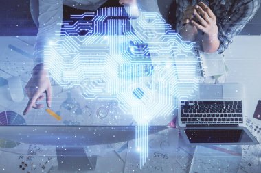 Kadın ve erkeğin birlikte çalışması ve insan beyin hologramı çizimi. Beyin fırtınası konsepti. Bilgisayar arkaplanı. Üst Görünüm.