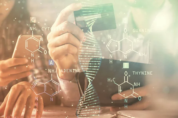 Dupla exposição de homem e mulher compras on-line segurando um cartão de crédito e desenho de holograma de DNA. Conceito de educação médica e comércio eletrônico . — Fotografia de Stock