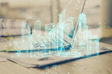 Ofisteki masaüstü bilgisayar geçmişi ve büyük kasaba binaları hologram çizimi. Çifte maruziyet. Akıllı şehir konsepti.