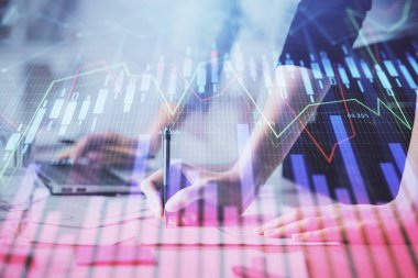 Bilgisayarda ve finansal grafik hologramında yazı yazan kadın ellerine çok maruz kalmış. Borsa analizi kavramı.