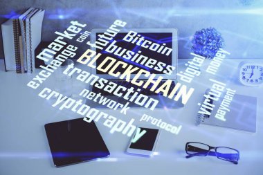 Engelleme zinciri ve kripto ekonomi temalı hologram ve bilgisayar geçmişi olan bir masa. Bitcoin kripto para kavramı.
