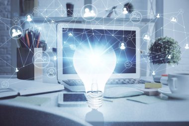 Bilgisayar ofisinde ampul simgesi hologramıyla birlikte. Çifte maruziyet. Fikir kavramı.