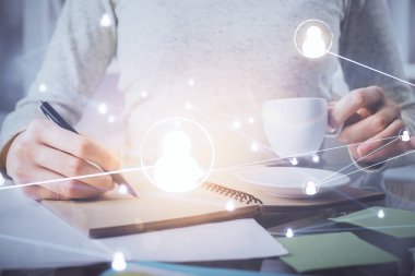 Sosyal ağ temalı hologram ellerin not almasından üstündür. Küresel uluslararası insan kavramı bağlanıyor. Çift pozlama