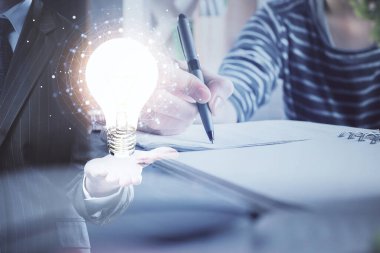 Kadın elinin üstüne ampul çizip arka planda not almak. Fikir kavramı. Çift pozlama