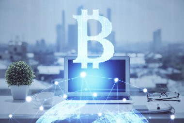 Engelleme zinciri ve kripto ekonomi temalı hologram ve bilgisayar geçmişi olan bir masa. Bitcoin kripto para kavramı.