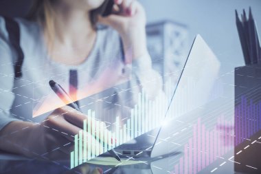Bilgisayarda ve finansal grafik hologramında kadın eli yazarken çift pozlama. Borsa analizi kavramı.