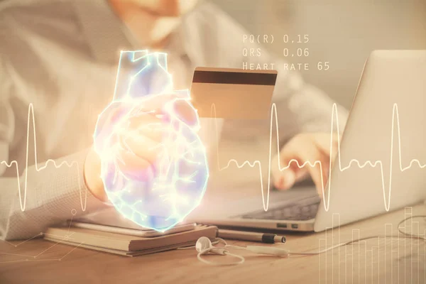 Double exposure of man hands holding a credit card and human heart drawing. Medical education and E-commerce concept. — Stock Photo, Image