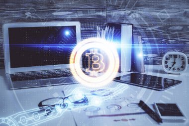 Engelleme zinciri ve kripto ekonomi temalı hologram ve bilgisayar geçmişi olan bir masa. Bitcoin kripto para kavramı.