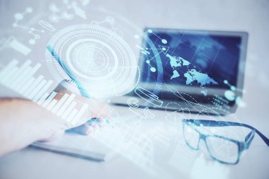 Arkaplanda iş simgeleri olan not defterinde yazan adamın çifte pozlandırılması.