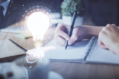 Kadın elinin üstüne ampul çizip arka planda not almak. Fikir kavramı. Çift pozlama