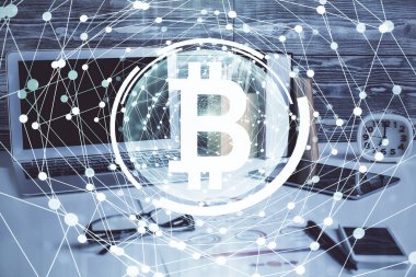 Engelleme zinciri ve kripto ekonomi temalı hologram ve bilgisayar geçmişi olan bir masa. Bitcoin kripto para kavramı.