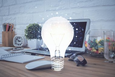 Bilgisayar ofisinde ampul simgesi hologramıyla birlikte. Çifte maruziyet. Fikir kavramı.