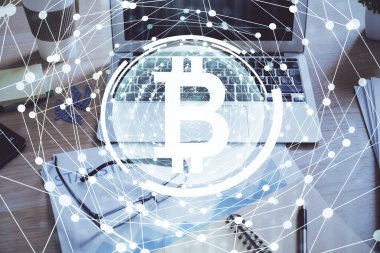 Engelleme zinciri ve kripto ekonomi temalı hologram ve bilgisayar geçmişi olan bir masa. Bitcoin kripto para kavramı.