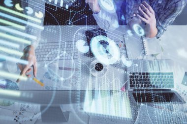 Kadın ve erkeğin birlikte çalışması ve veri temalı hologram çizimi. Bilgisayar arkaplanı. Üst Görünüm.