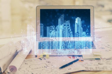 Ofisteki masaüstü bilgisayar geçmişi ve büyük kasaba binaları hologram çizimi. Çifte maruziyet. Akıllı şehir konsepti.