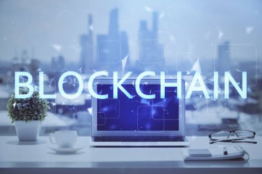 Engelleme zinciri ve kripto ekonomi temalı hologram ve bilgisayar geçmişi olan bir masa. Bitcoin kripto para kavramı.