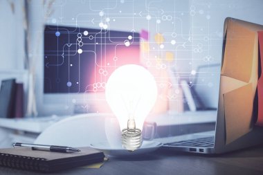 Bilgisayar ofisinde ampul simgesi hologramıyla birlikte. Çifte maruziyet. Fikir kavramı.