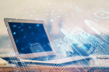 Ofisteki masaüstü bilgisayar geçmişi ve büyük kasaba binaları hologram çizimi. Çifte maruziyet. Akıllı şehir konsepti.