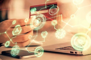 İnternetten alışveriş yapan kadının elinde kredi kartı ve sosyal ağ temalı bir çizim var. İlişki E-ticaret kavramı.