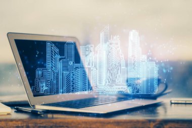 Ofisteki masaüstü bilgisayar geçmişi ve büyük kasaba binaları hologram çizimi. Çifte maruziyet. Akıllı şehir konsepti.