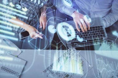 Kadın ve erkeğin birlikte çalışması ve veri temalı hologram çizimi. Bilgisayar arkaplanı. Üst Görünüm.