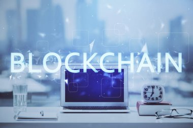 Engelleme zinciri ve kripto ekonomi temalı hologram ve bilgisayar geçmişi olan bir masa. Bitcoin kripto para kavramı.