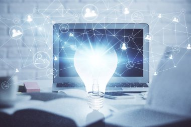 Bilgisayar ofisinde ampul simgesi hologramıyla birlikte. Çifte maruziyet. Fikir kavramı.