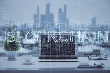 Engelleme zinciri ve kripto ekonomi temalı hologram ve bilgisayar geçmişi olan bir masa. Bitcoin kripto para kavramı.