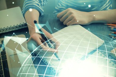 Dünya haritası hologramı ve veri tema simgeleriyle notlar alan ellerin çifte pozlanması. Uluslararası ağ verilerinin kavramı.