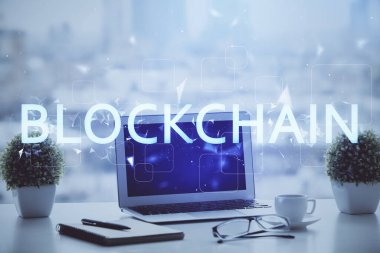 Engelleme zinciri ve kripto ekonomi temalı hologram ve bilgisayar geçmişi olan bir masa. Bitcoin kripto para kavramı.