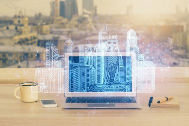 Ofisteki masaüstü bilgisayar geçmişi ve büyük kasaba binaları hologram çizimi. Çifte maruziyet. Akıllı şehir konsepti.