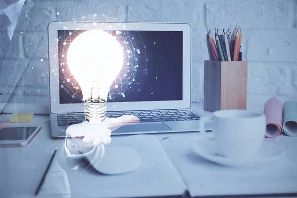 Ordenador en el escritorio en la oficina con el holograma icono de la bombilla. Doble exposición. Concepto de idea. — Foto de Stock