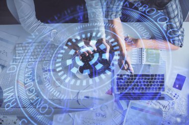 Kadın ve erkeğin birlikte çalışması ve veri temalı hologram çizimi. Bilgisayar arkaplanı. Üst Görünüm.