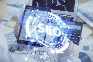 Erkeklerin el ele tutuşup dijital bir cihaz ve seo çizimi kullanırken birden fazla pozlama. arama optimizasyonu kavramı.