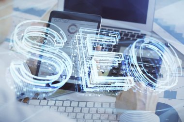 Erkeklerin el ele tutuşup dijital bir cihaz ve seo çizimi kullanırken birden fazla pozlama. arama optimizasyonu kavramı.