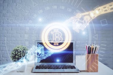 Engelleme zinciri ve kripto ekonomi temalı hologram ve bilgisayar geçmişi olan bir masa. Bitcoin kripto para kavramı.