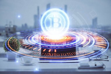 Engelleme zinciri ve kripto ekonomi temalı hologram ve bilgisayar geçmişi olan bir masa. Bitcoin kripto para kavramı.