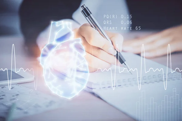 Heart hologram over womans hands writing background. Concept of Medical education study. Double exposure — Stock Photo, Image