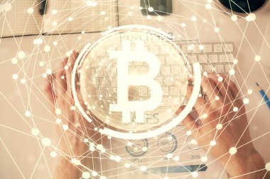 Erkeklerin ellerinin bilgisayar klavyesini ve şifreli para birimi temalı hologram çizimini yazarken çift pozlama. Üst Manzara. Engelleme zinciri kavramı.