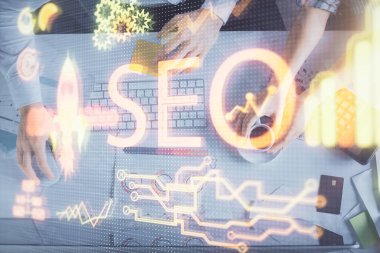 SEO hologram çizimleri ve birlikte çalışan kadın ve erkeğin çifte pozu. Arama motoru konsepti. Bilgisayar arkaplanı. Üst Görünüm.