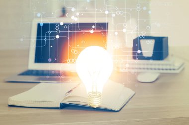 Bilgisayar ofisinde ampul simgesi hologramıyla birlikte. Çoklu maruz kalma. Fikir kavramı.