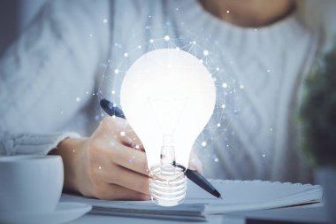 Kadın elinin üstüne ampul çizip arka planda not almak. Fikir kavramı. Çift pozlama