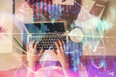 Bilgisayar ve finansal temalı hologram çizimleri üzerinde çalışan kadın elleri çift pozlama. Üst Manzara. İş konsepti.