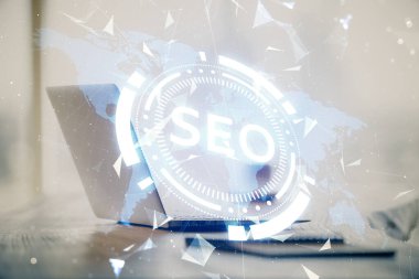 Bilgisayar ve seo çizim hologramı olan bir masanın çifte görüntüsü. Arama optimizasyon kavramı.