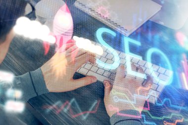 Arka planda bilgisayar üzerinde çalışan bir adamla birlikte çok sayıda simgeye maruz kalma. Arama motoru optimizasyonu kavramı.